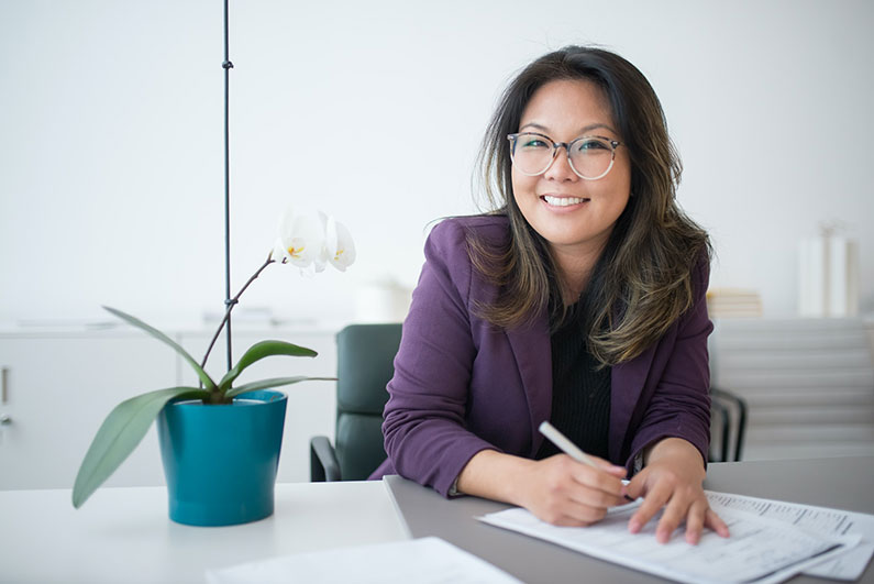 A woman at a desk is doing paperwork