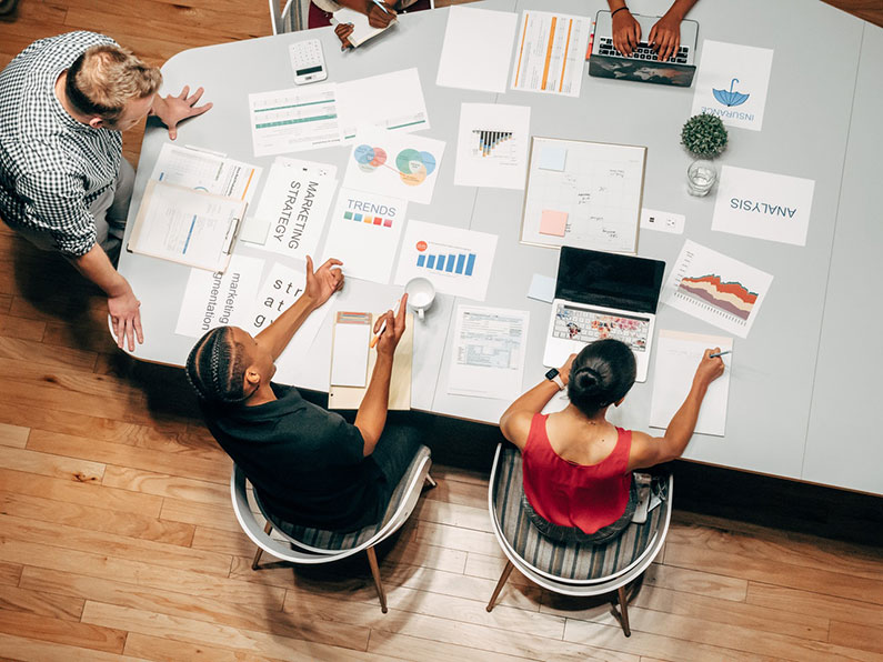 Employees around a table working late