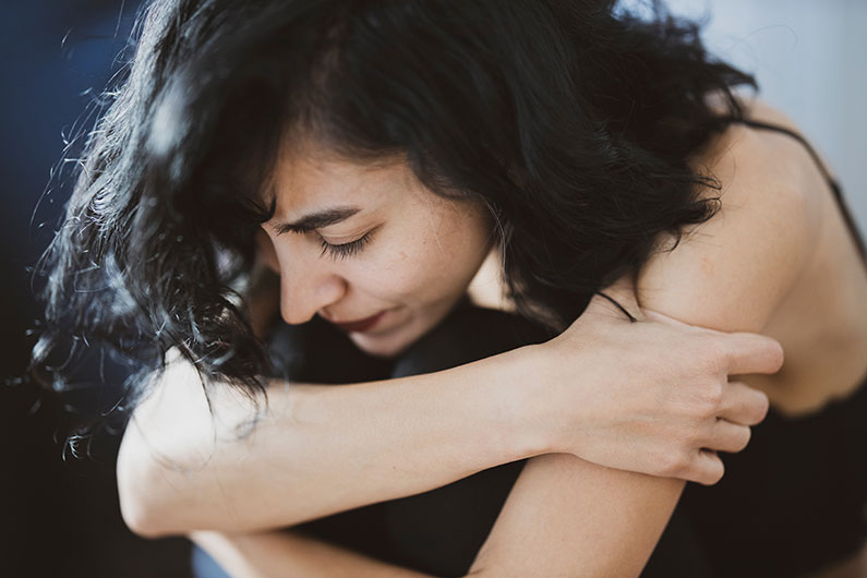 Closeup of a woman hugging her knees to her chest